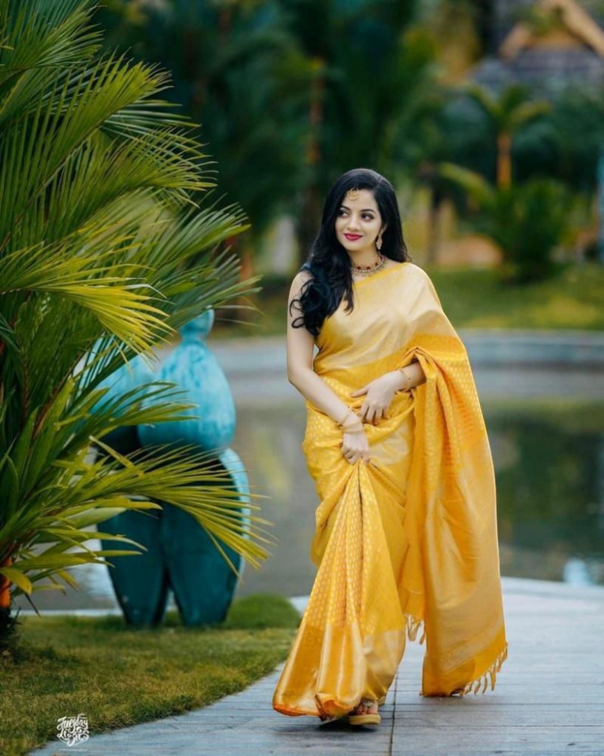 Woman wearing a vibrant yellow RK Collectives litchi silk Banarasi-style jacquard saree with a shimmering border